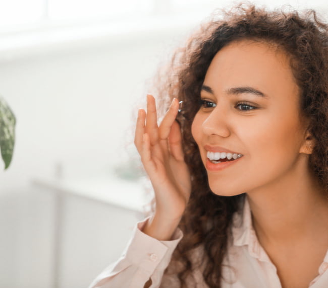 young woman putting in contact lenses