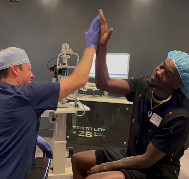 Dr. Parkhurst high-fiving his LASIK patient, Tre
