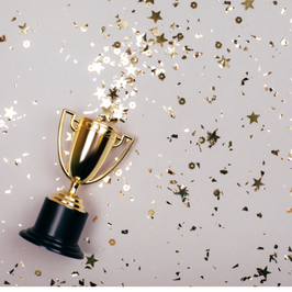 small award laying on the table with confetti